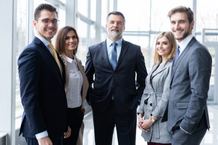 Happy business team with arms crossed at the office