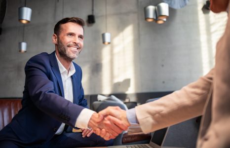 Business people shaking hands during meeting in cafe