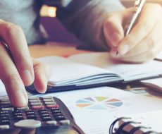 Close up hand man doing finance and calculate on desk about cost at home office.